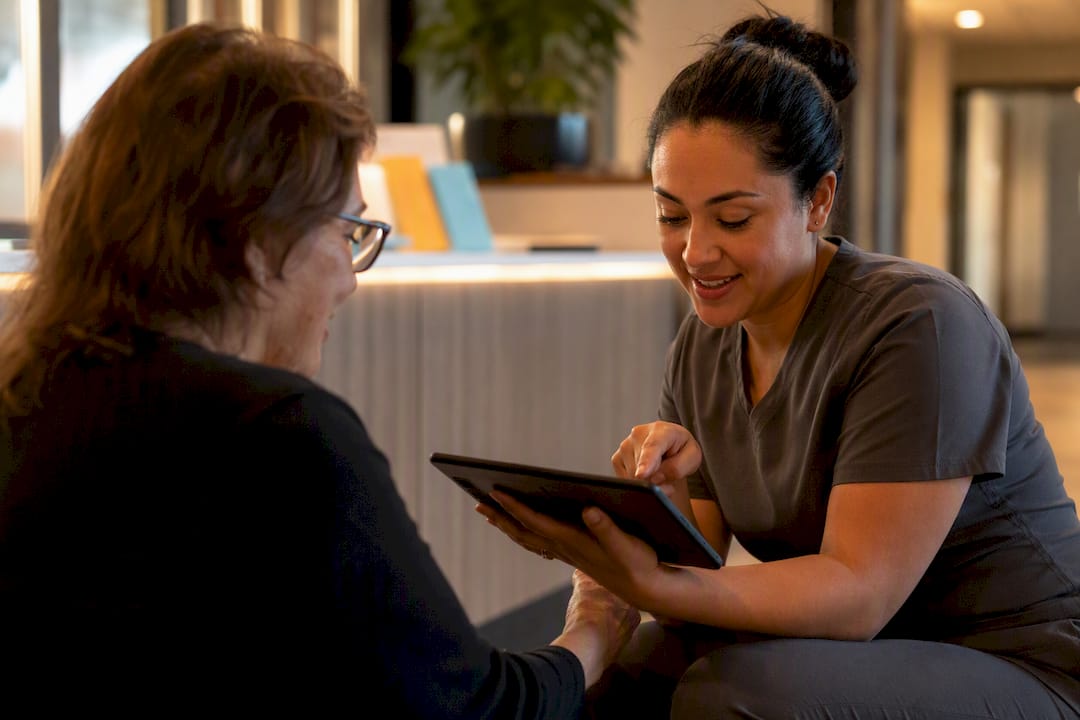 Clinic staff helping patient enroll on tablet